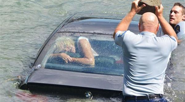 بالصور: سرعة بديهة شرطي تنقذ سائقة من الغرق المحتم